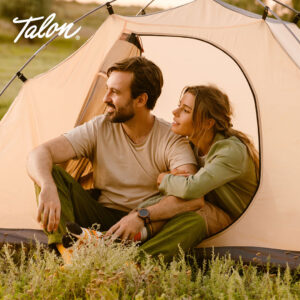 Man and woman sitting camping in a tent.